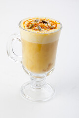 hot pumpkin latte with pumpkin seeds in a transparent glass