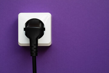 white socket and black plug  on purple background