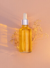 glass bottle with serum on a light background with sun glare