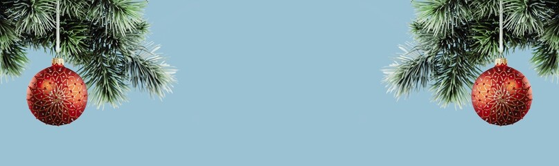 Christmas ornaments. Red glass bauble on Christmas tree branch. Happy new year greeting card. Copy space banner