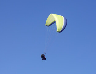 A couple of people in the air in a tandem paraglider in La Meije