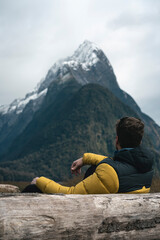 young man looking at the spectacular fjords in Milford Sound. New Zealand landscape