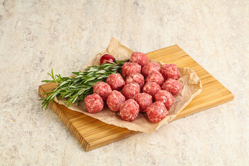 Raw uncooked beef meatballs served rosemary