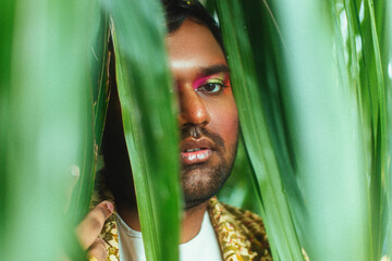 portrait of dark skinned man surrounded by leaves