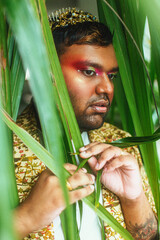 portrait of dark skinned man surrounded by leaves