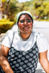 dark skinned Indian non-binary individual smiling in park