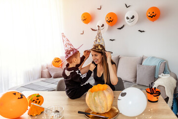 Getting ready for Halloween. Family bonding during Halloween. Mother and son playing together during Halloween night. Mother and son have fun and celebrate Halloween