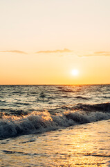 Sandy seashore. Sea surf. Sunset on the sea.