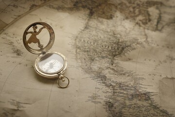 Retro style antique golden compass (sundial) and old nautical chart close-up. Vintage still life. Sailing accessories. Wanderlust, travel and navigation theme. Graphic resources, copy space