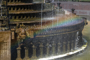 A rainbow is located on the fountain cascade.