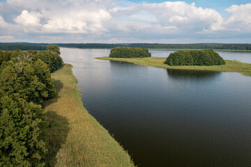 Fototapeta premium Aerial view of green islands and clouds at summer sunny day. Masurian Lake District in Poland. 