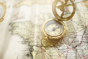 Retro style antique golden compass (sundial) and old nautical chart close-up. Vintage still life....