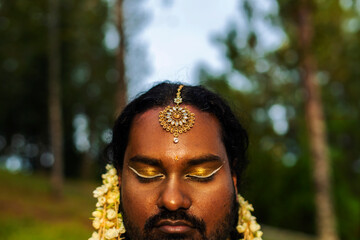 portrait of dark skinned Indian non-binary individual with traditional female attire in park