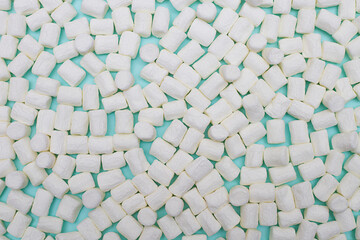 Abstract background of white marshmallows on blue paper.