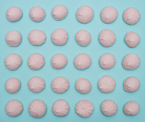 A pattern of pink marshmallows on blue paper.