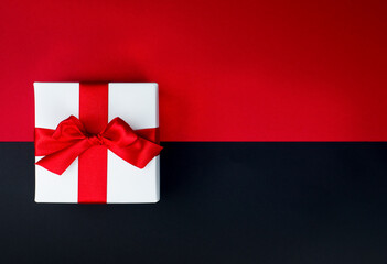 White gift box with red ribbon and bow