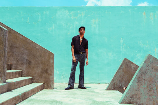 fashion portrait of dark skinned Indian man in concrete surroundings