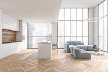 Modern white living room with blue sofa and kitchen