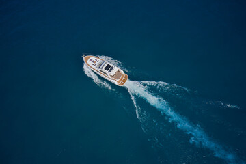 Luxury yacht on the water aerial view. White yacht fast movement on the water top view. Yacht...