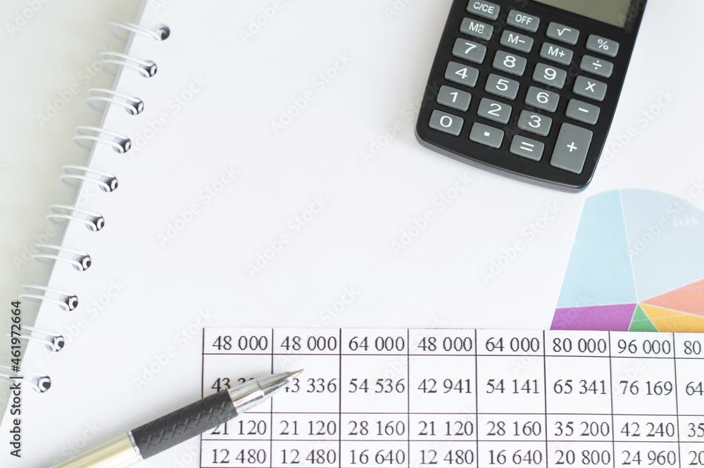 Aufkleber calculator and pen on blank notebook on the table next to financial statements