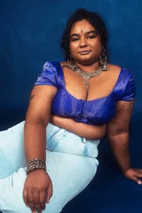 Fotobehang portrait of dark skinned Indian woman from Malaysia against a dark blue background © Daniel Adams