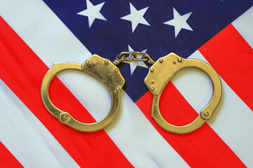 Handcuffs and American Flag. Usa legal system concept, handcuffs on money background and american...