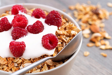 Sweet breakfast with granola, yogurt and fresh raspberries