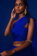 portrait of dark skinned Indian woman from Malaysia against a dark blue background
