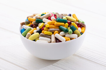 Plate full of colored pills and medical capsule