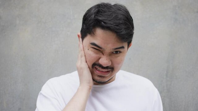 slow motion scene adult middle eastern man use hand massage on ear after feeling pain form eardrum syndrome for unhealthy lifestyle concept