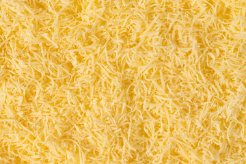 Grated cheese background texture. yellow shredded  cheese. Close up top view.