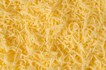 Grated cheese background texture. yellow shredded  cheese. Close up top view.