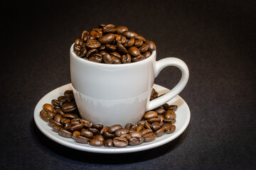 white espresso cup filled with coffee beans