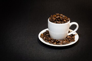 white espresso cup filled with roasted coffee beans