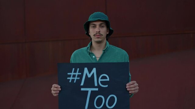 Portrait of man holding cardboard with hashtag me too