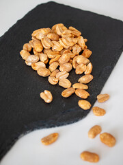 Roasted chili lemon peanuts on dark stone cutting board
