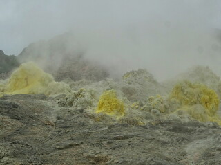 硫黄が噴き出し黄色に色ついた岩