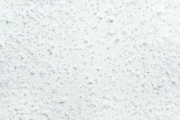 Coarse kitchen salt crystals scattered on a white background