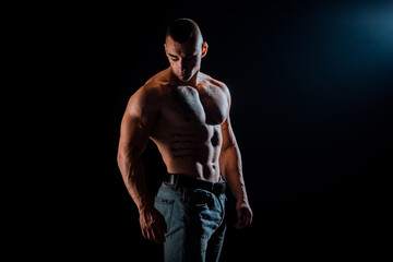 Fototapeta na wymiar Healthy muscular young man on a dark background