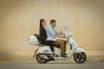 Two business people riding on the mototrcycle