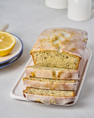 Traditional white glazed lemon bread with poppy seeds and citrus zest. Sliced homemade fruitcake. Sweet and delicious orange bakery. Vegetarian healthy dessert. Classic recipe