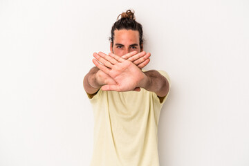 Young caucasian man isolated on white background doing a denial gesture