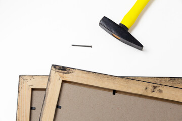 hammer and a nail next to wooden picture frames