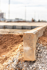 Repair of the sidewalk with the installation of a curbstone. Laying paving slabs in the pedestrian zone of the city. Motage of concrete curbs.