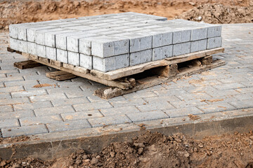 Storage of paving slabs on pallets at the construction site. Ready-to-install concrete paving slabs. Finished products warehouse.