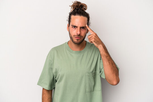 Young caucasian man isolated on gray background pointing temple with finger, thinking, focused on a task.