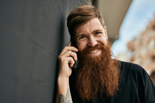 Young irish hipster man smiling happy talking on the smartphone at the city.