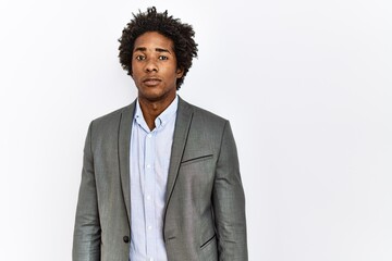 Young african american man wearing business jacket over isolated white background with serious expression on face. simple and natural looking at the camera.