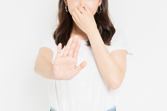 鼻をつまむTシャツを着た若い女性