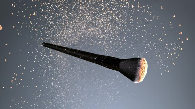 Super Slow Motion Shot of Flying and Rotating Makeup Brush and Brown Powder at 1000fps.